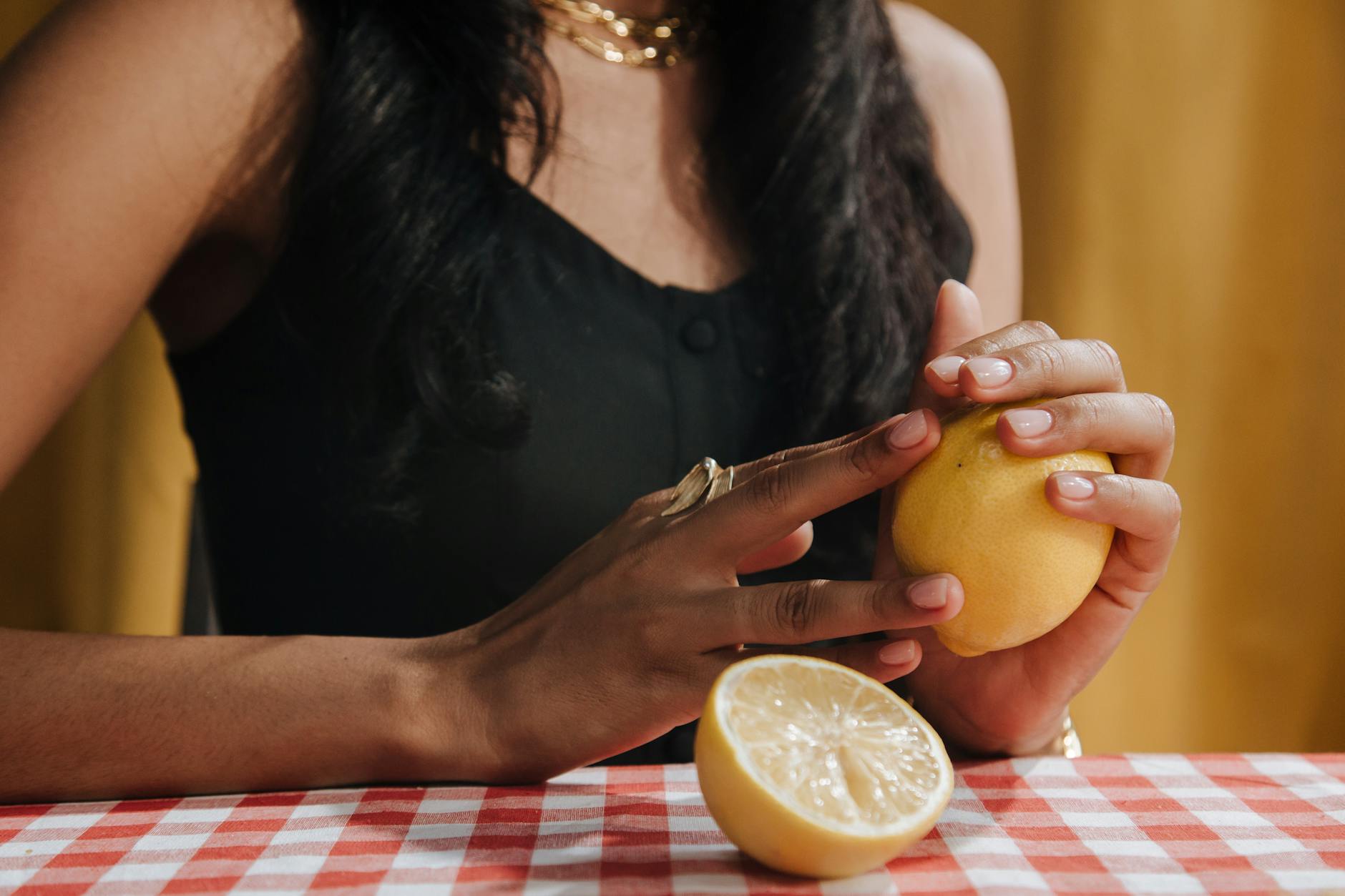 A hand holding a lemon vibrator against a minimalistic backdrop, symbolizing intimate connection and modern sensuality.