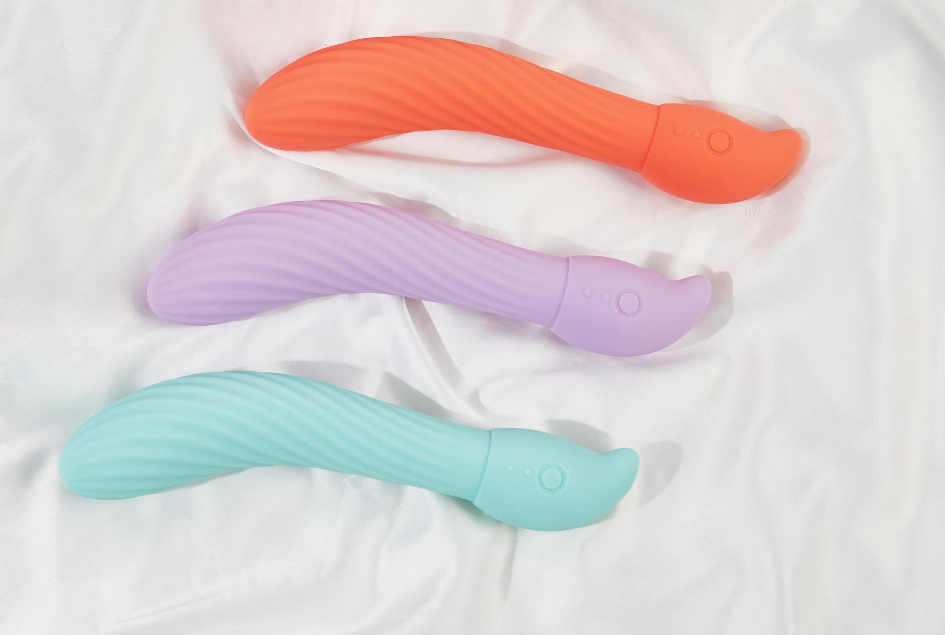Person thoughtfully holding different vibrators, comparing options