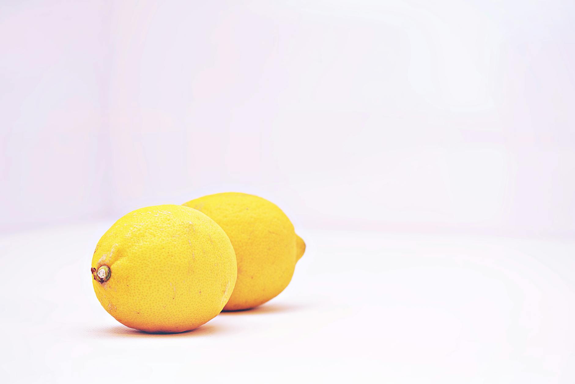 Two vibrant lemons on a white background, fresh and unguarded
