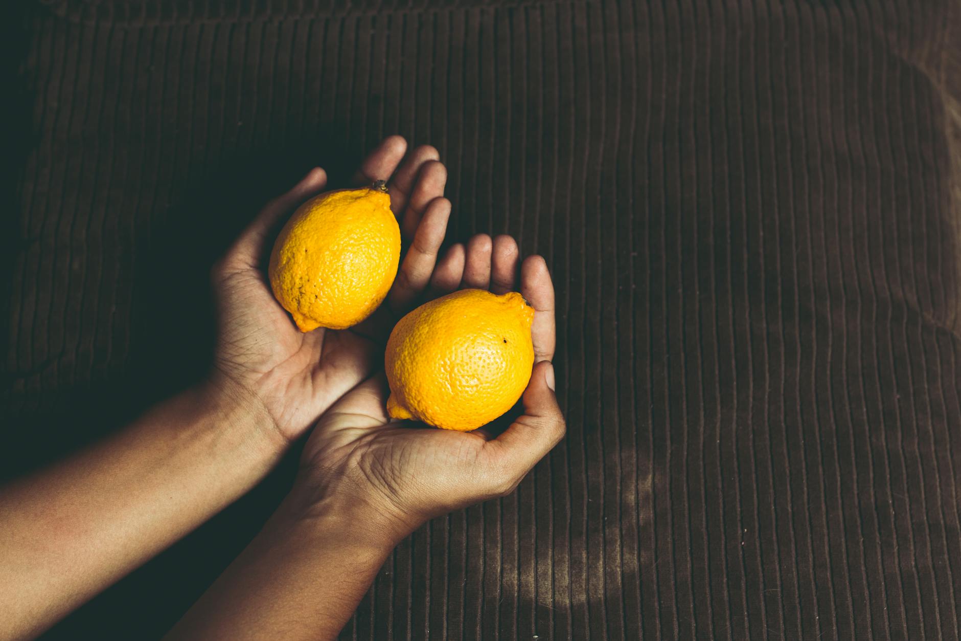 Vibrant lemons on yellow background, symbolizing fresh sensory experience